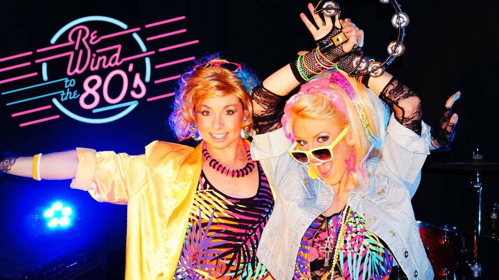 Two women dressed up for an 80s tribute night