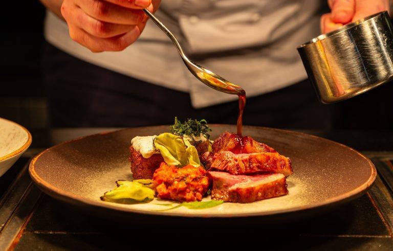 Chef serving fine dining meat main course at Cocina Restaurant in the Peak District, Chesterfield